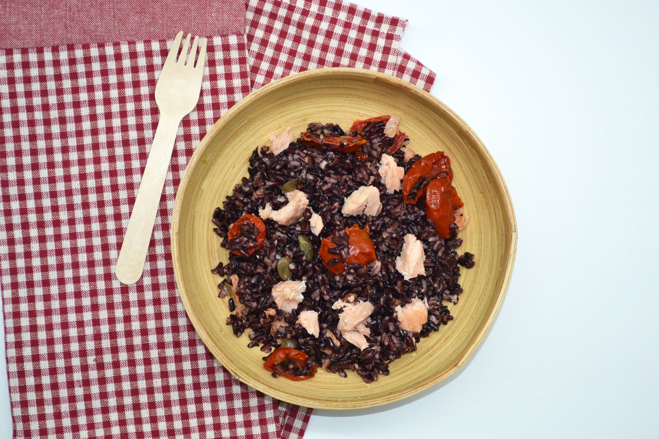 Riso nero e salmone con capperi e pomodorini