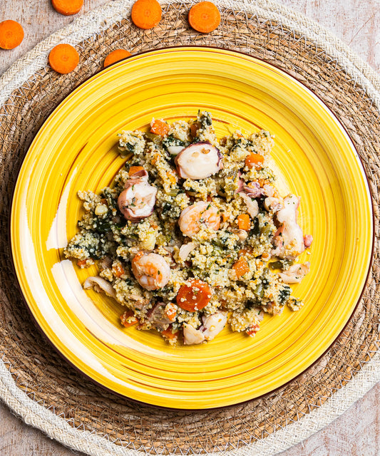 Piatto in ceramica giallo vibrante con cous cous e verdure, vongole, calamari e gamberi colorati in primo piano