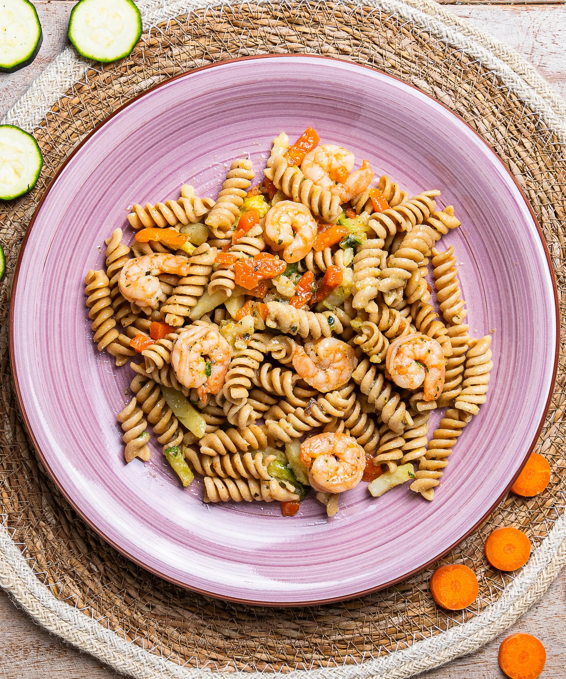 Piatto rosa vivace con fusilli integrali gamberi e verdure colorate per insalata di pasta senza cereali contenenti glutine