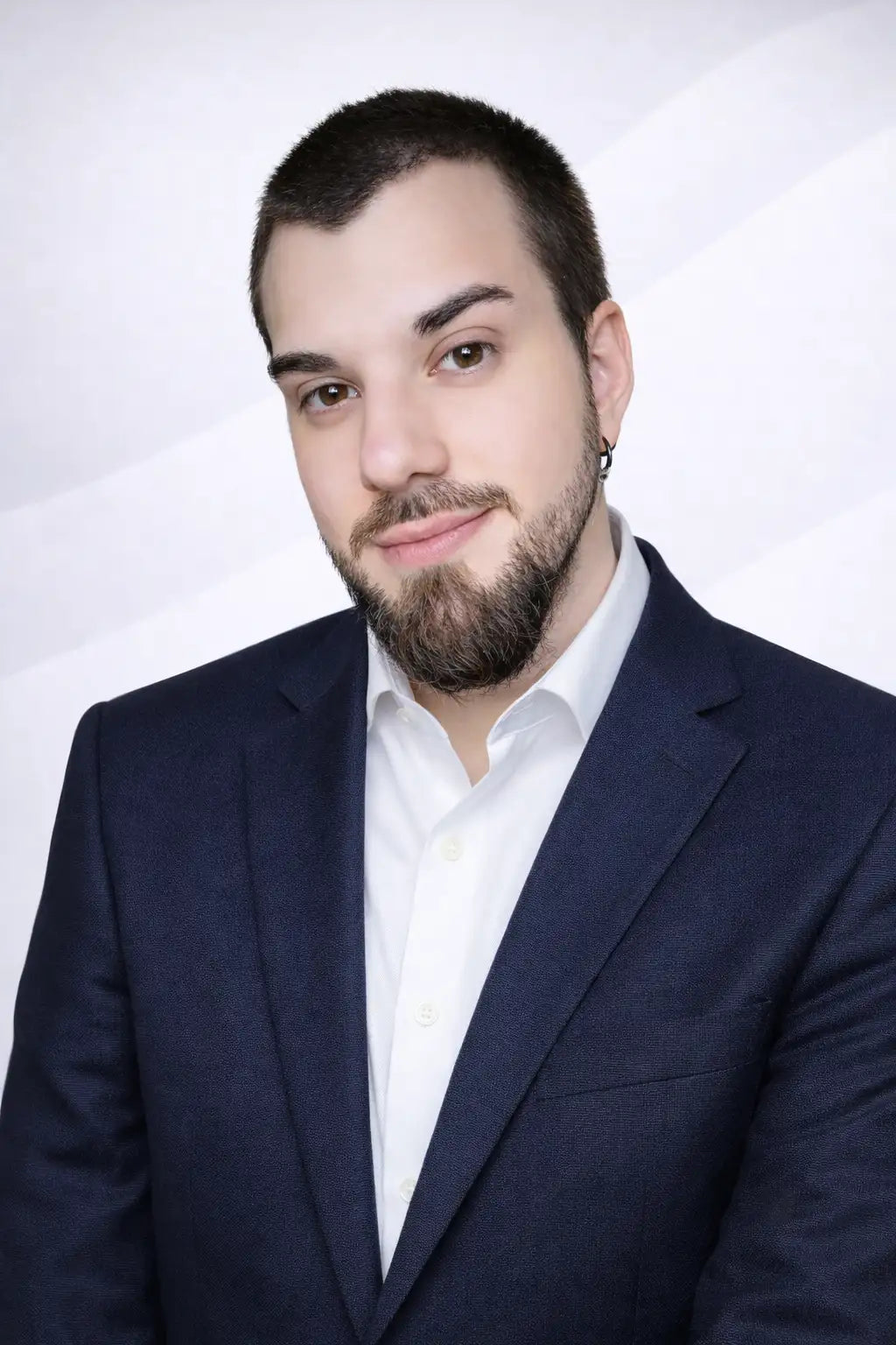Un uomo che indossa una giacca blu navy in tessuto strutturato sopra una camicia bianca elegante e ben stirata.