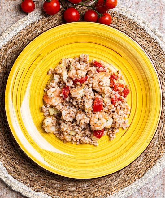 Piatto ceramica giallo vibrante con insalata di farro gamberi patate e pomodorini con design a coste concentriche