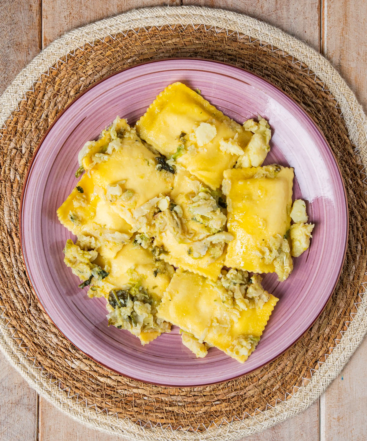 Quadrotti ripieni di ricotta con patate e verza dorati con ripieno verde serviti su piatto in ceramica lavanda