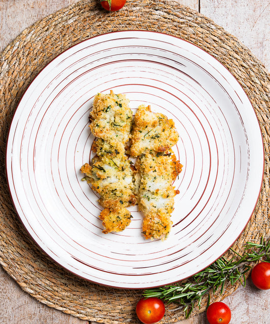 Crispy herb-crusted spiedini misti fish fillets served on a white plate with concentric brown lines