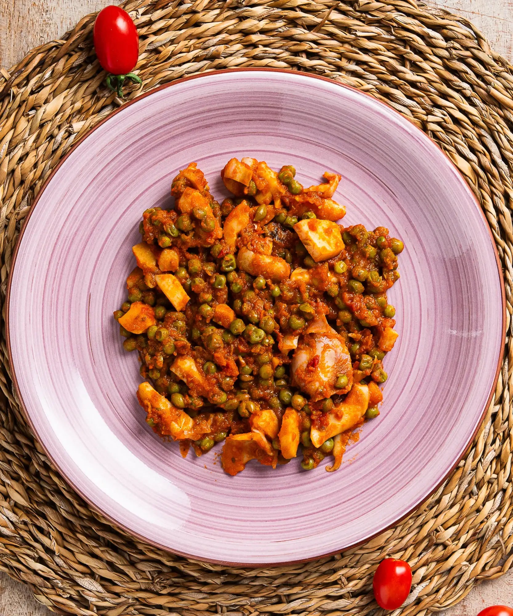 Un vivace piatto di ceramica viola con solchi concentrici ospita un colorato piatto di verdure saltate e proteine in una ricca salsa saporita.